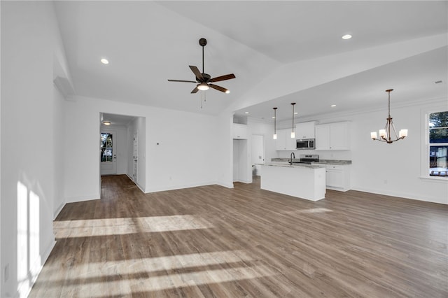 unfurnished living room with light hardwood / wood-style flooring, high vaulted ceiling, ceiling fan with notable chandelier, and sink