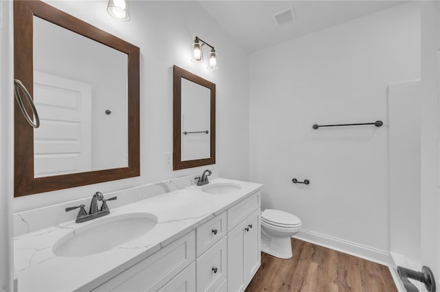 bathroom with vanity, hardwood / wood-style flooring, and toilet