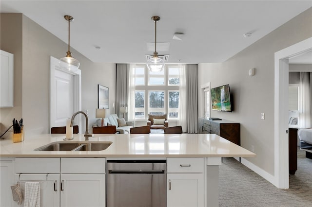 kitchen with white cabinets, pendant lighting, light colored carpet, and sink