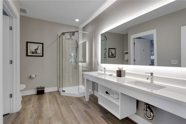 bathroom featuring a shower with shower door, toilet, wood-type flooring, and vanity