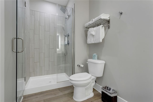 bathroom with walk in shower, toilet, and hardwood / wood-style flooring