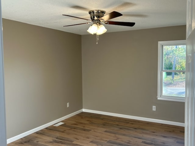 spare room with dark hardwood / wood-style floors, ceiling fan, and a textured ceiling