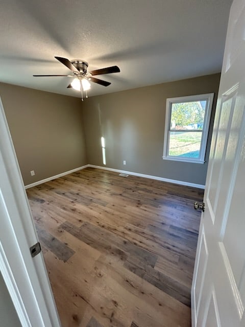 empty room featuring hardwood / wood-style floors and ceiling fan