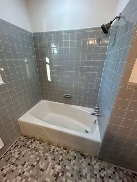 bathroom featuring tile patterned flooring, tiled shower / bath, and tile walls