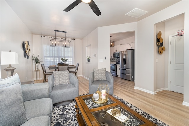 living room with ceiling fan and wood-type flooring