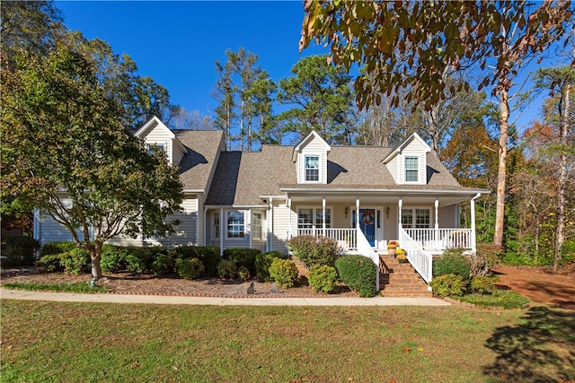 cape cod house with covered porch and a front yard