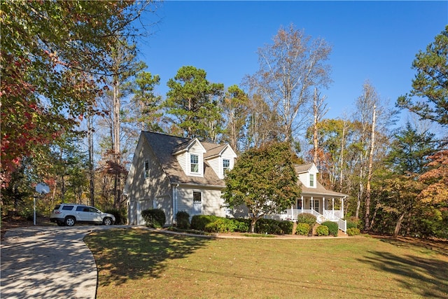 cape cod-style house featuring a front yard, a porch, and a garage