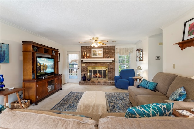 living room featuring ceiling fan, a brick fireplace, crown molding, a textured ceiling, and light carpet