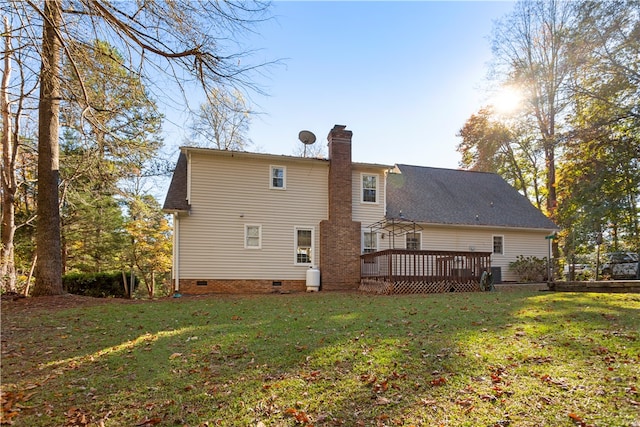 rear view of property with a yard and a wooden deck