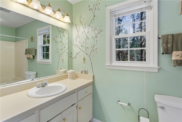 bathroom featuring a shower, vanity, and toilet