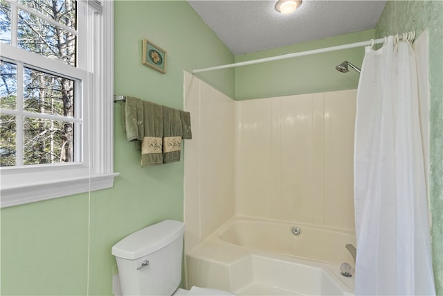 bathroom with shower / bath combo, a textured ceiling, and toilet