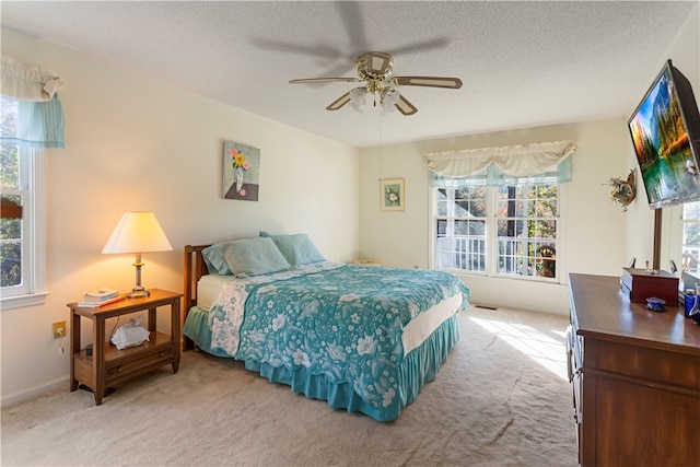 carpeted bedroom featuring a textured ceiling and ceiling fan