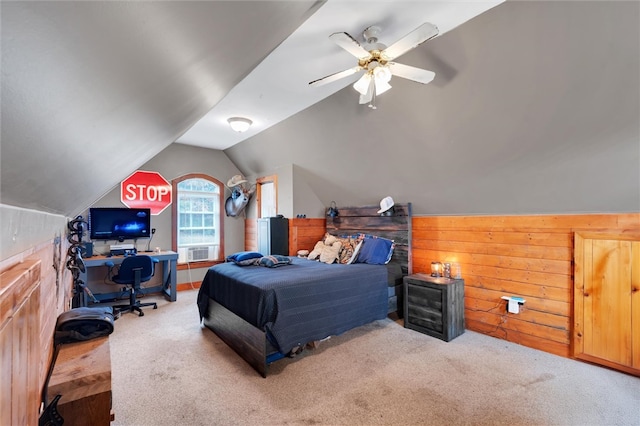 bedroom with ceiling fan, wood walls, light colored carpet, and lofted ceiling