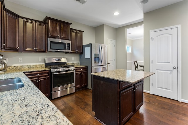 kitchen with light stone counters, dark wood-type flooring, and appliances with stainless steel finishes