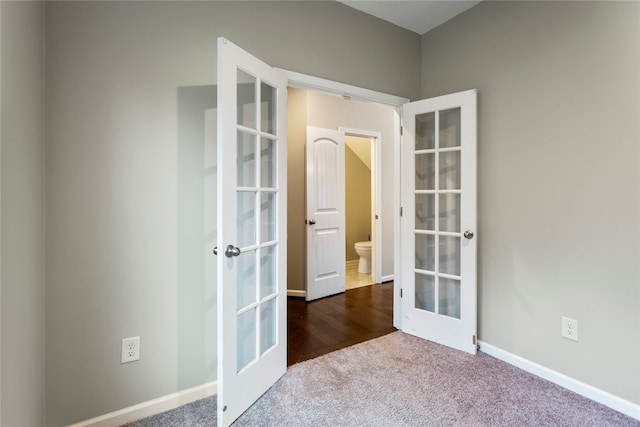 empty room with dark carpet and french doors