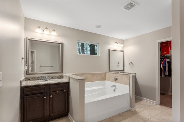 bathroom featuring a washtub, vanity, and tile patterned flooring