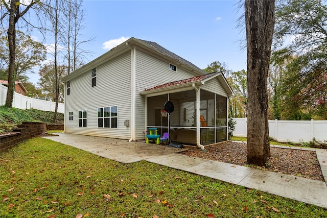 back of house featuring a sunroom, a patio area, and a yard