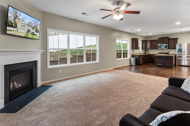 living room with ceiling fan and dark hardwood / wood-style floors