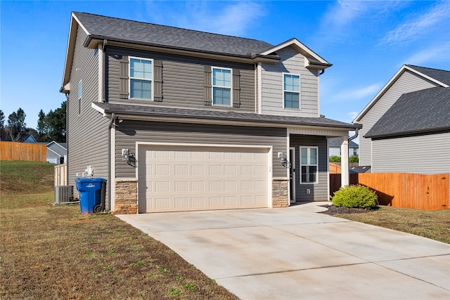 front facade featuring central air condition unit, a front lawn, and a garage