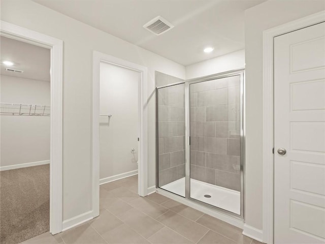 bathroom with a shower with shower door and tile patterned flooring