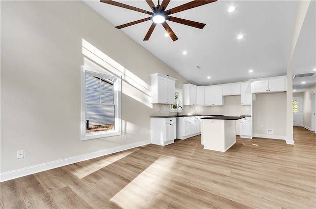 kitchen with white cabinets, a wealth of natural light, a kitchen island, and ceiling fan