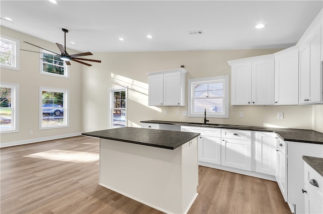 kitchen with a center island, white cabinetry, a wealth of natural light, and light hardwood / wood-style flooring