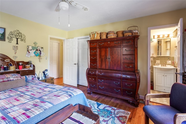 bedroom with connected bathroom, ceiling fan, sink, dark hardwood / wood-style floors, and a closet