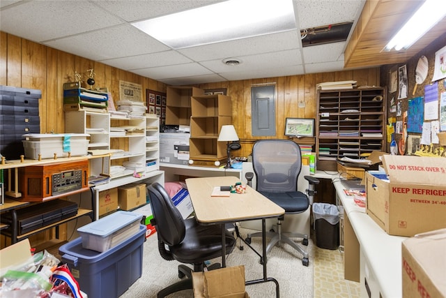 office area featuring electric panel, a drop ceiling, and wooden walls