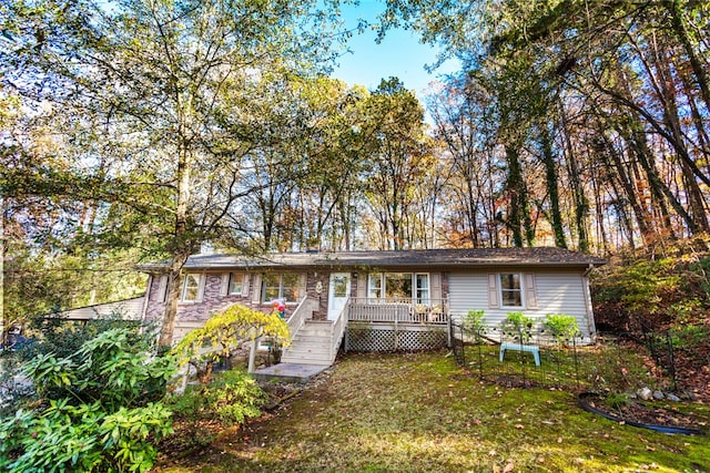 single story home featuring a wooden deck and a front lawn