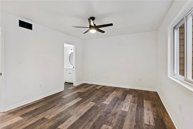 unfurnished bedroom with connected bathroom, ceiling fan, and dark wood-type flooring