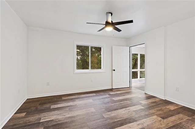 unfurnished room with a wealth of natural light, ceiling fan, and dark wood-type flooring