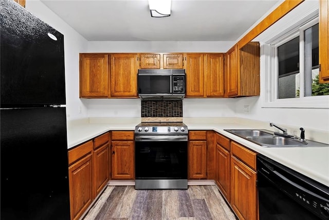 kitchen with dark hardwood / wood-style flooring, sink, and black appliances