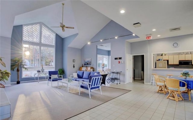 tiled living room featuring ceiling fan and high vaulted ceiling