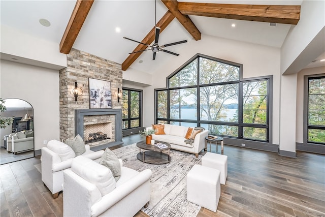 living room featuring dark hardwood / wood-style flooring, plenty of natural light, high vaulted ceiling, and a fireplace