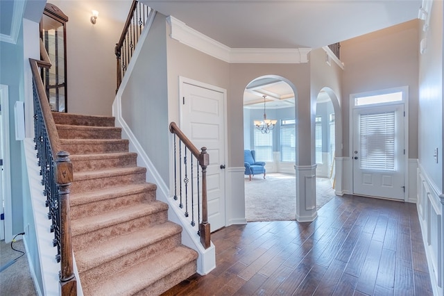 foyer with crown molding, dark wood-type flooring, and a wealth of natural light