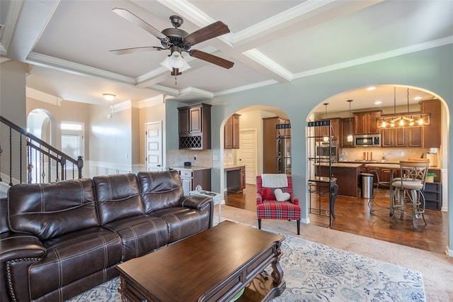 living room featuring coffered ceiling, crown molding, ceiling fan, beamed ceiling, and wood-type flooring