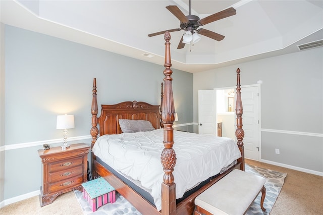 carpeted bedroom featuring ceiling fan and a raised ceiling