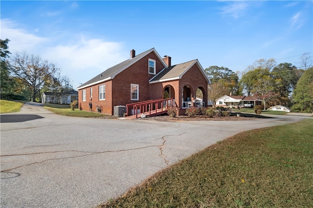 front of property with a front yard, a porch, and central AC unit