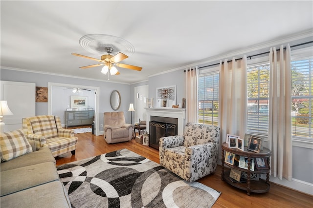 living room with crown molding, light hardwood / wood-style flooring, and ceiling fan