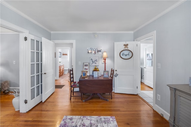 dining space with light hardwood / wood-style floors and crown molding