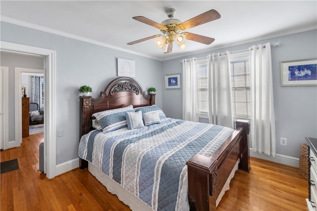 bedroom featuring ceiling fan, light hardwood / wood-style floors, and ornamental molding