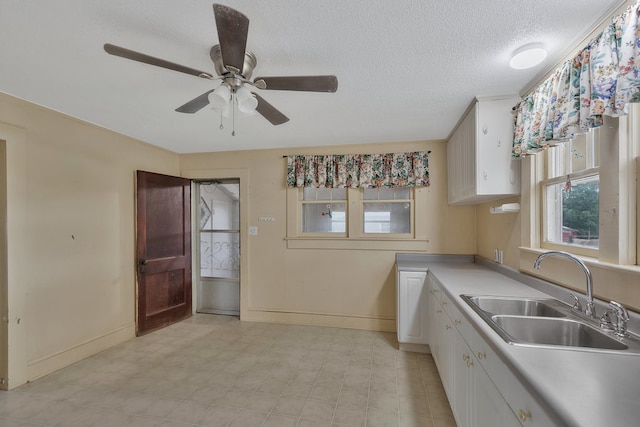 kitchen featuring white cabinets, a textured ceiling, ceiling fan, and sink