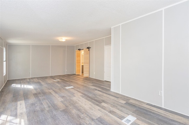 unfurnished room featuring a textured ceiling and hardwood / wood-style flooring