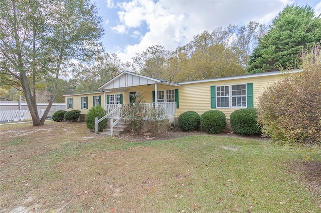 ranch-style home with covered porch and a front yard