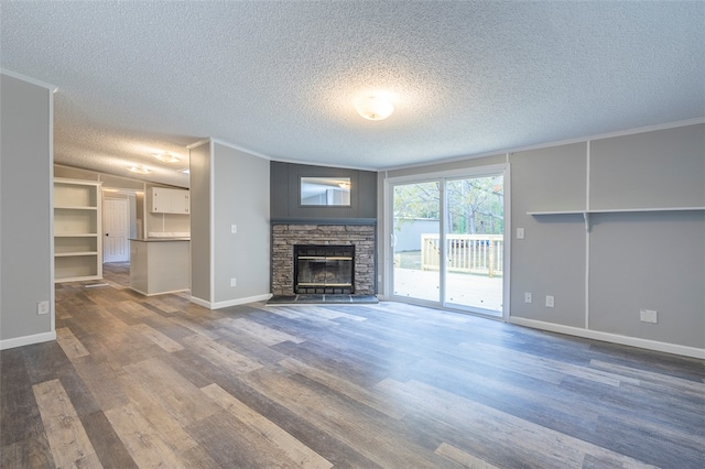 unfurnished living room featuring a fireplace, dark hardwood / wood-style flooring, a textured ceiling, and ornamental molding