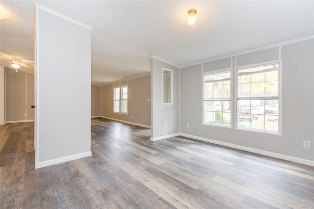 empty room with a healthy amount of sunlight, dark hardwood / wood-style flooring, ornamental molding, and a textured ceiling