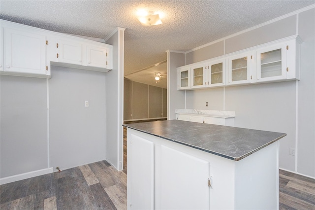 kitchen with white cabinets, dark hardwood / wood-style floors, and ornamental molding