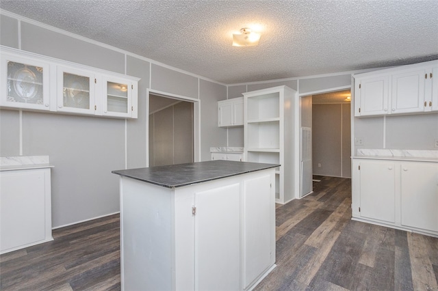 kitchen featuring dark hardwood / wood-style flooring, white cabinetry, and a textured ceiling