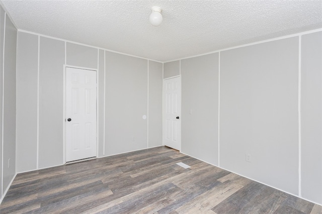 unfurnished room featuring dark hardwood / wood-style flooring and a textured ceiling