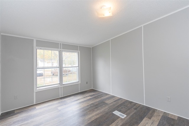 empty room with crown molding, wood-type flooring, and a textured ceiling